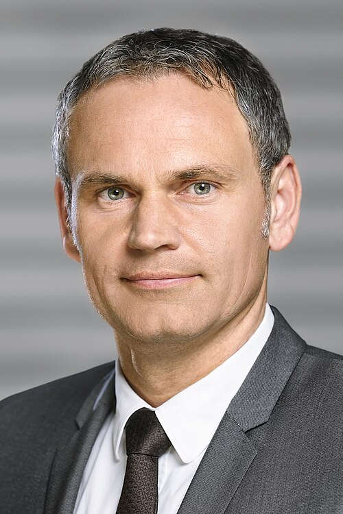 Porträtt av Dr. Oliver Blume, VD för Porsche AG, i grå kostym och slips.