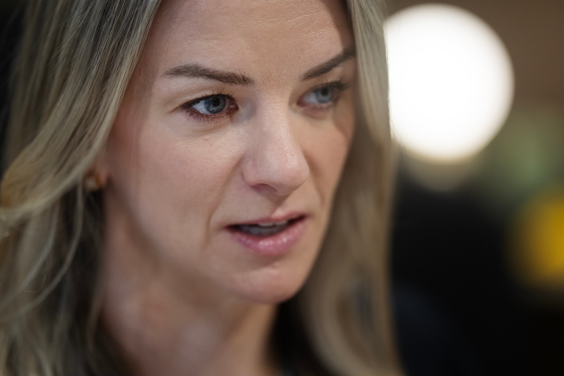 Porträtt av en kvinna med långt blont hår som tittar åt sidan