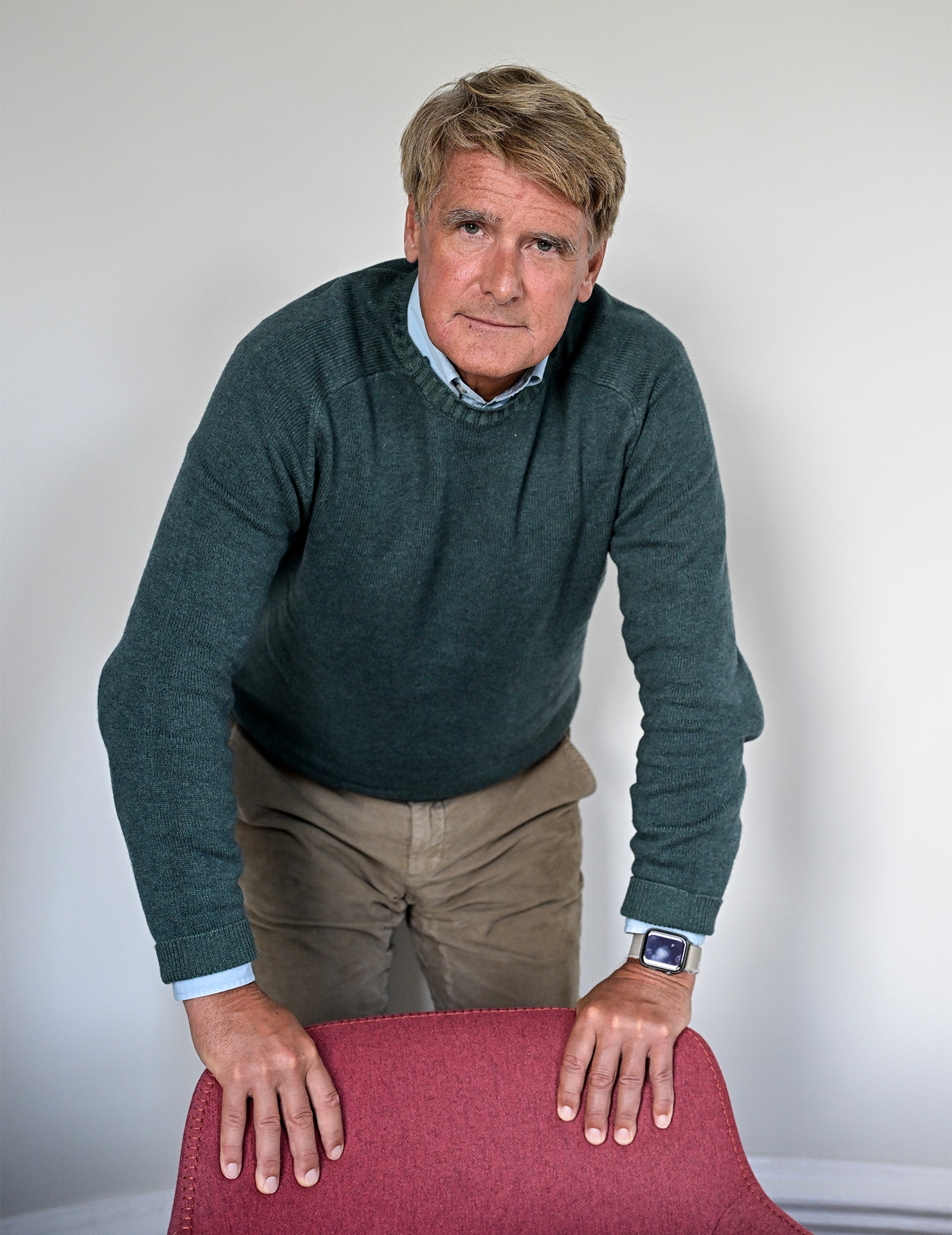 Finansmannen Christer Gardell varnar för riskerna med private credit och pekar på låg transparens. Han står bestämd vid en stol och har händerna på stolsryggen.