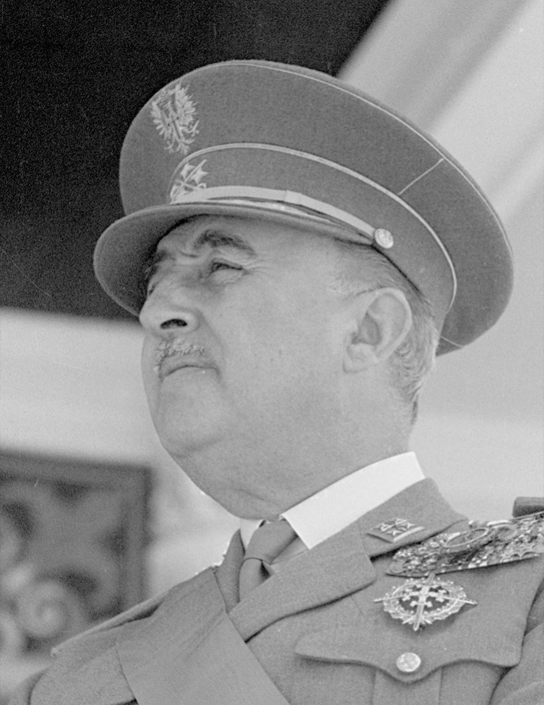 Porträtt av man i militär uniform med keps och medaljer, fotograferad i profil.