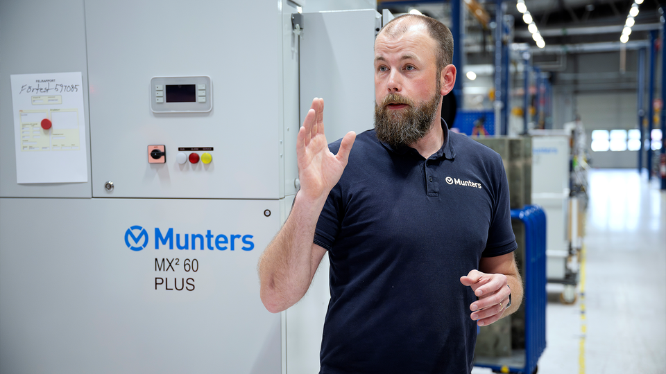 Tommy Strömberg kommer att bli fabrikschef i Tobo. Han pekar med handen. Han står på lagret i fabriken.