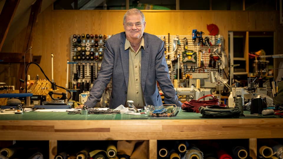 Martin Nordin står vid en arbetsdesk. Runt honom är en drös verktyg.