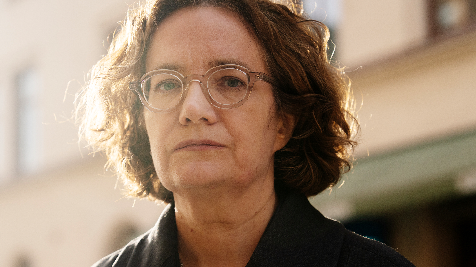 Porträtt av en person med glasögon och allvarligt uttryck