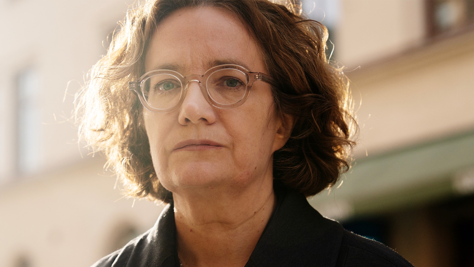 Porträtt av en person med glasögon och allvarligt uttryck