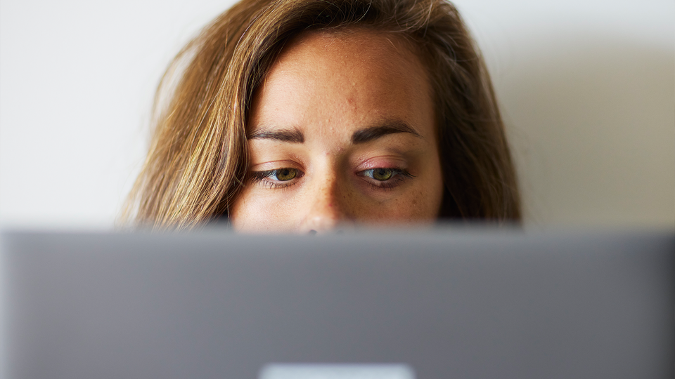 Julia Ravanis tittar fram bakom en dator i sitt hem.