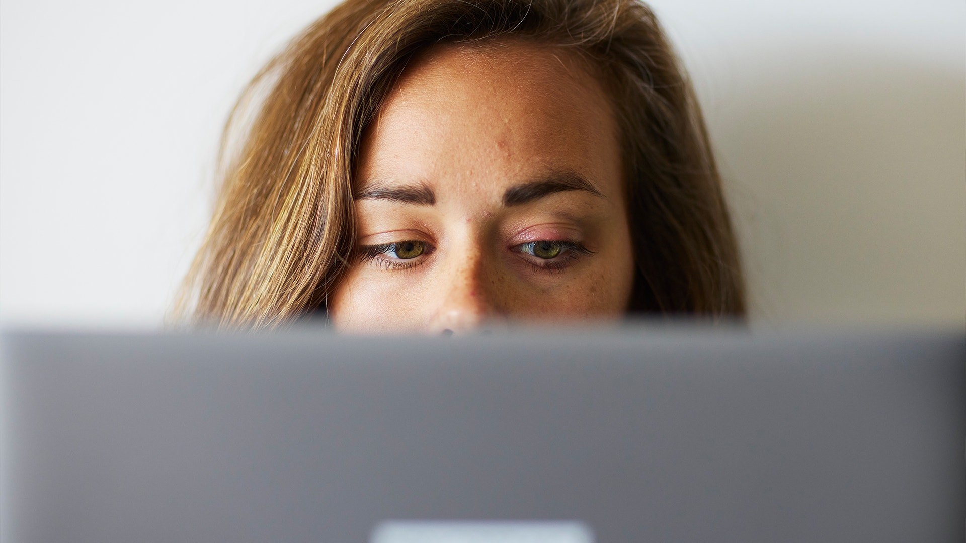 Julia Ravanis tittar fram bakom en dator i sitt hem.