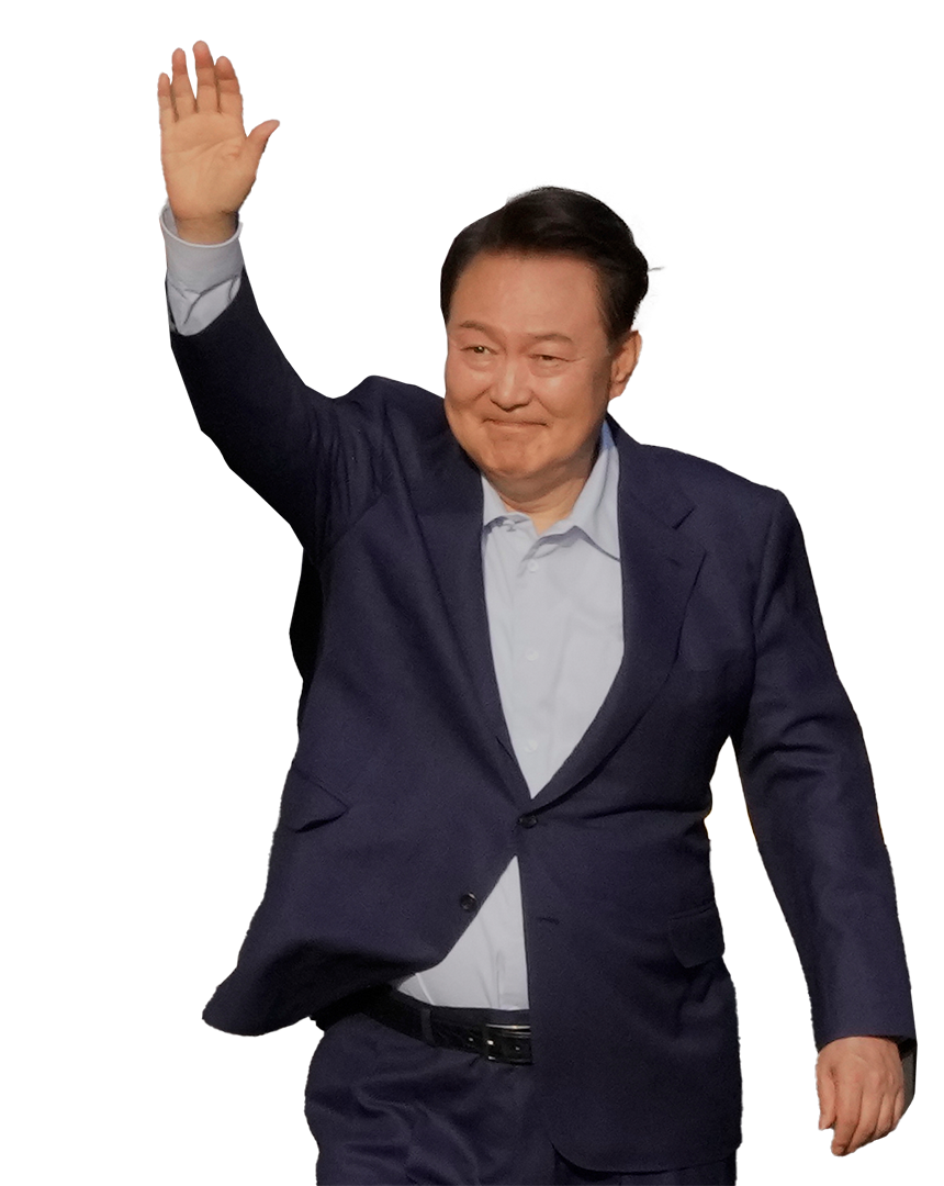 Yoon Suk Yeol står och räcker upp handen och ler. 