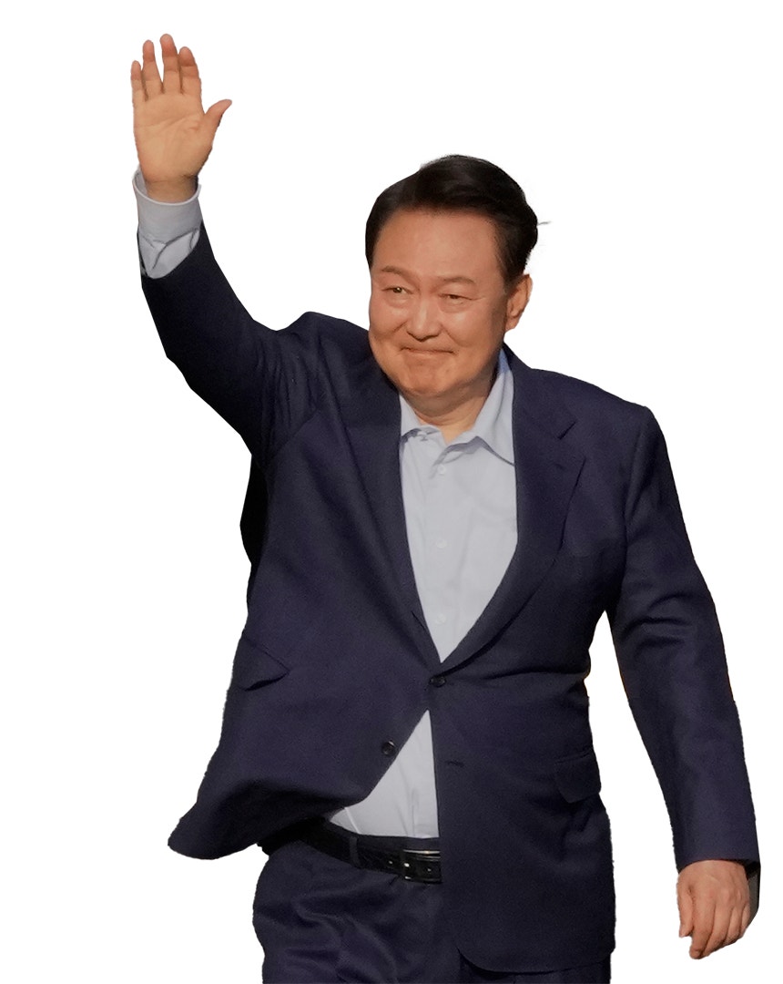 Yoon Suk Yeol står och räcker upp handen och ler.