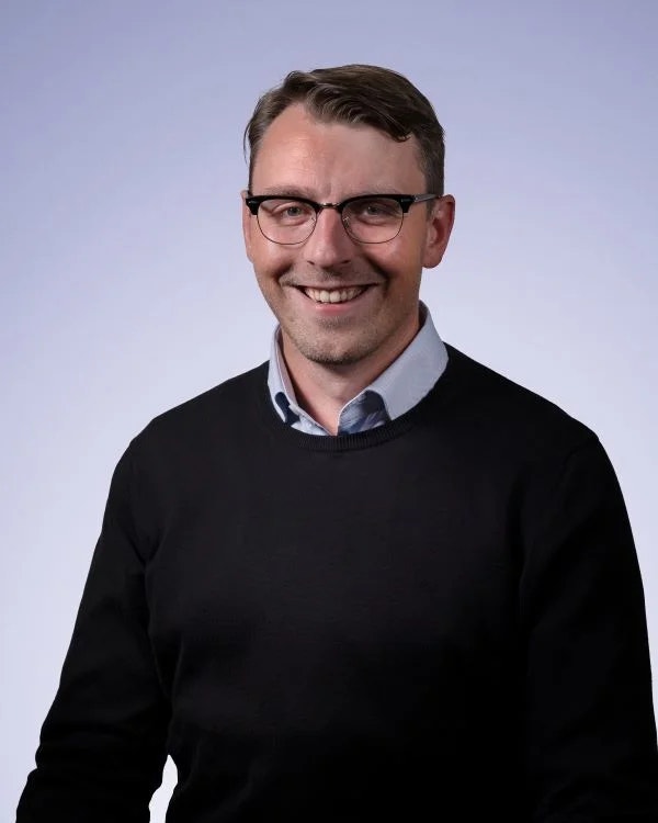 Porträttfoto av en man som ler mot kameran