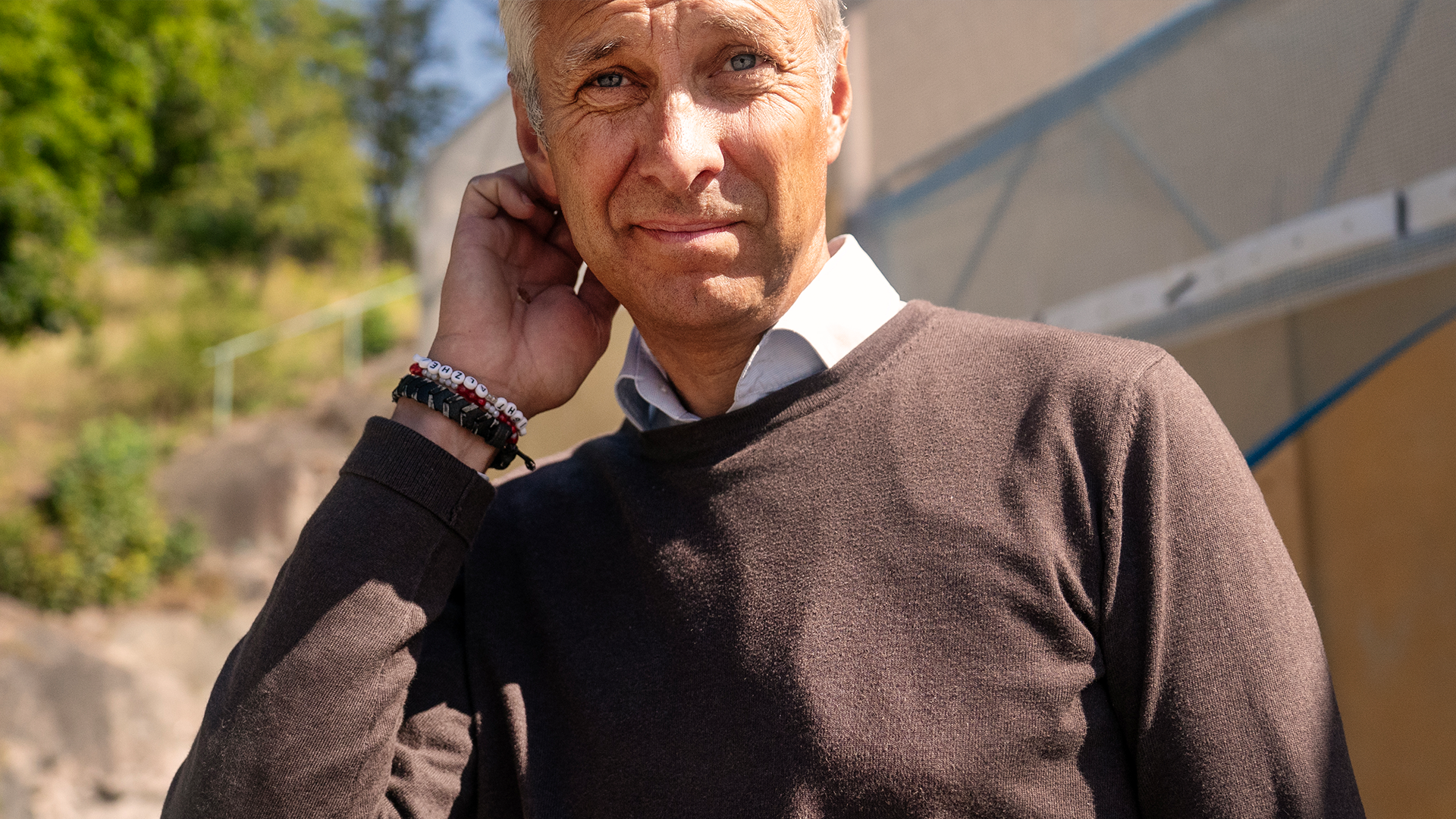 David von Schinkel står utomhus i ett soligt augusti-Stockholm. Han har vit skjorta och svart pullover.