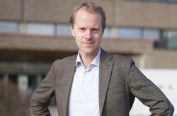 Porträttfoto av Anders Frick i affärskläder framför Volvo Cars huvudkontor i Göteborg