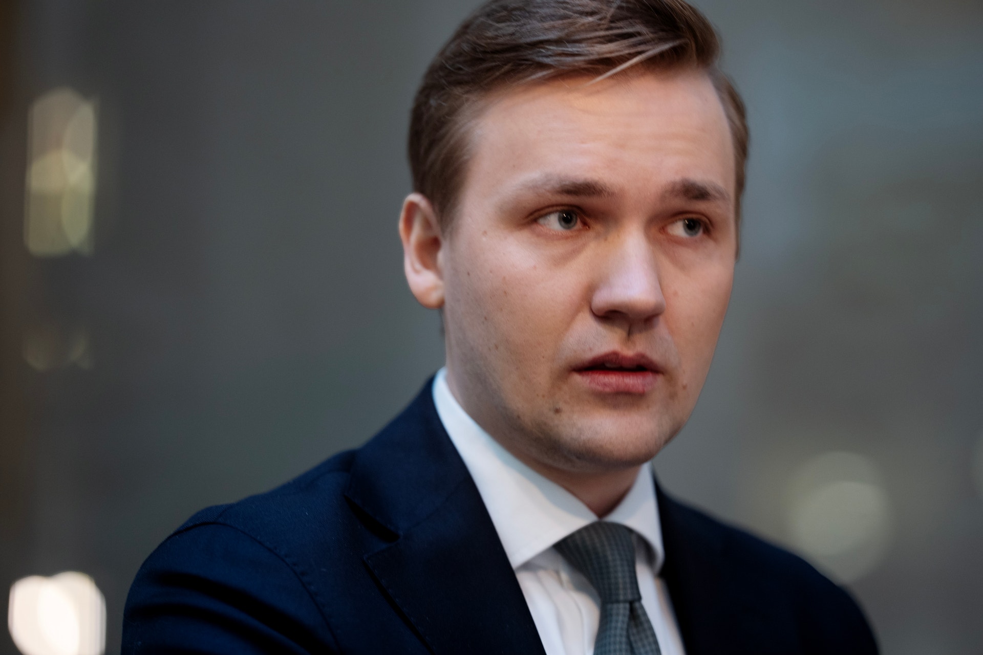 Porträtt av en man i mörkblå kostym och slips