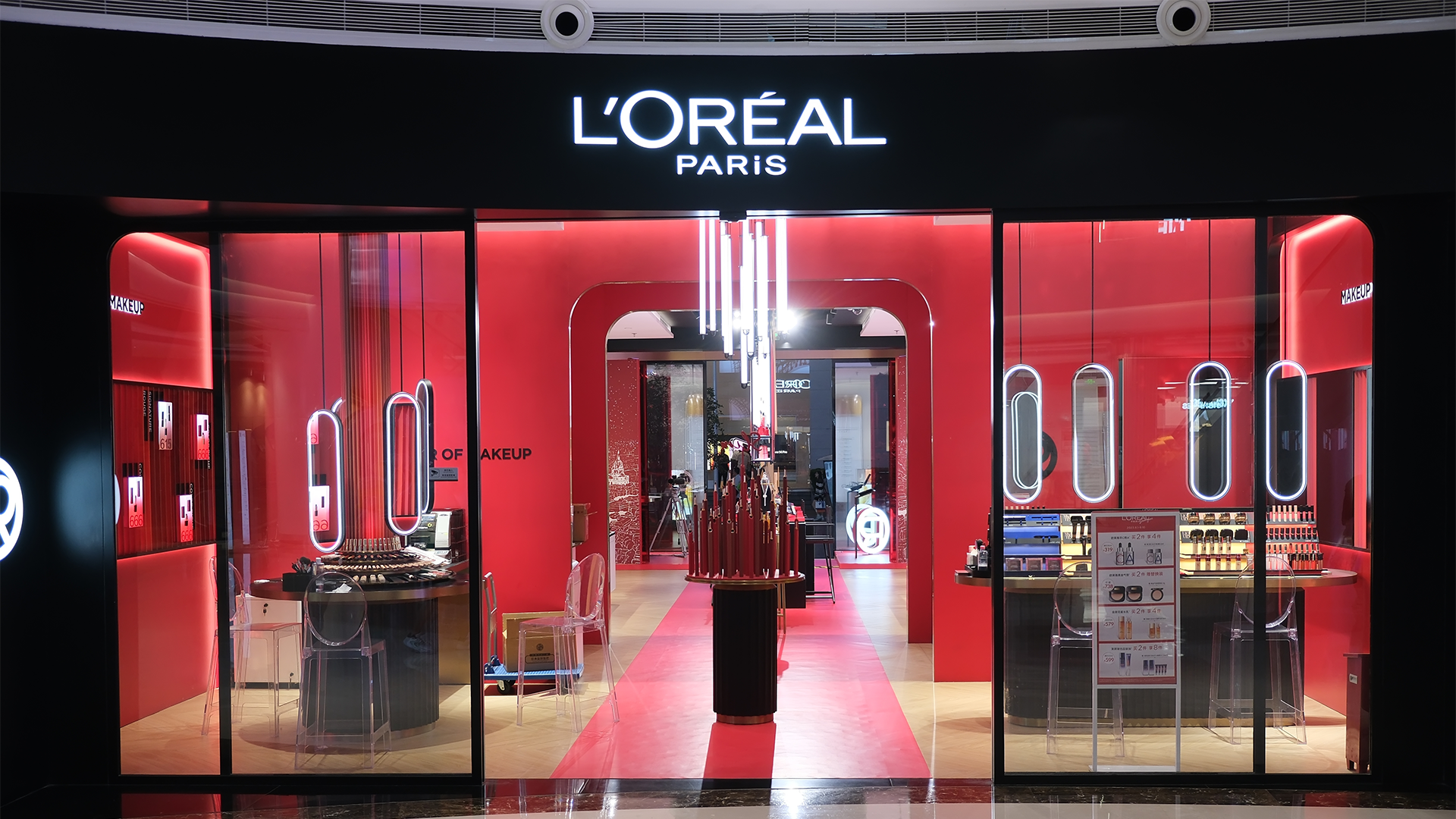 Entrén till en L'Oréal Paris-butik med röd inredning och skyltfönster med smink.