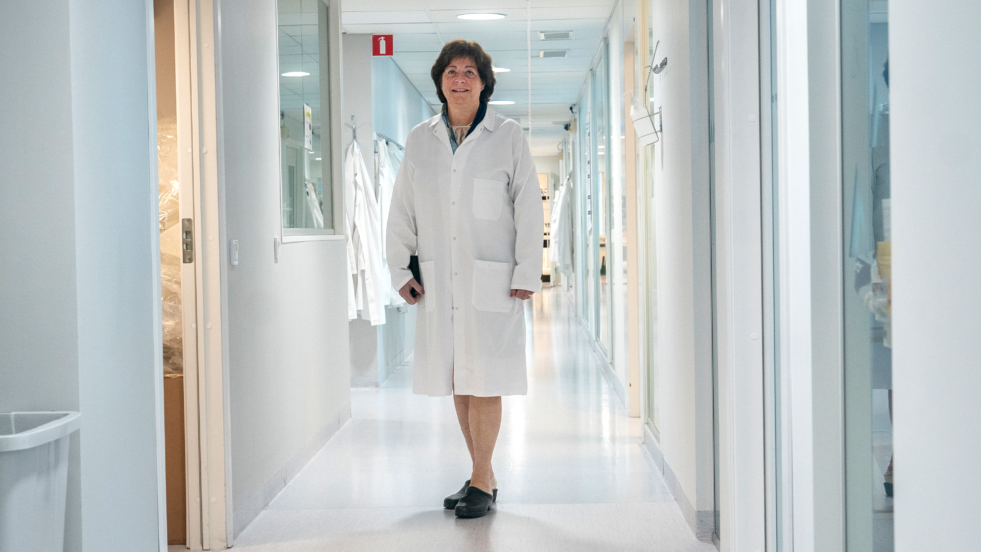 Gunilla Osswald går genom korridorerna på Bioarctics labb. Hon bär en vit rock.