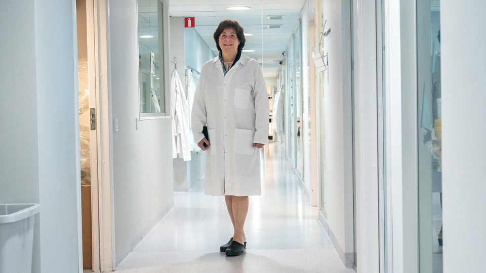 Gunilla Osswald går genom korridorerna på Bioarctics labb. Hon bär en vit rock.