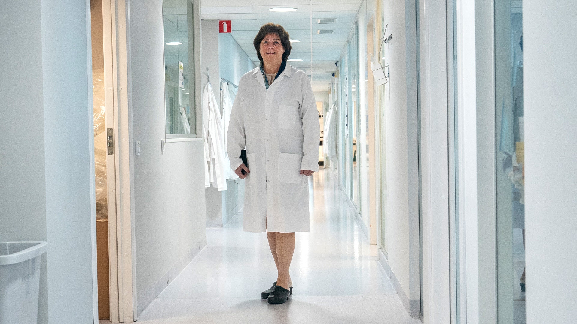 Gunilla Osswald går genom korridorerna på Bioarctics labb. Hon bär en vit rock.