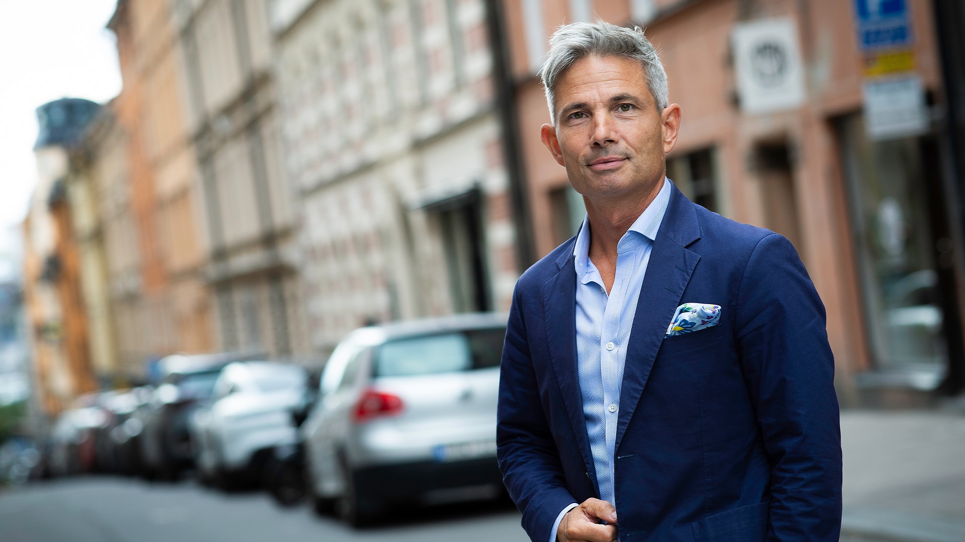 Daniel Waldenström på Stockholms gator klädd i blå kostym.