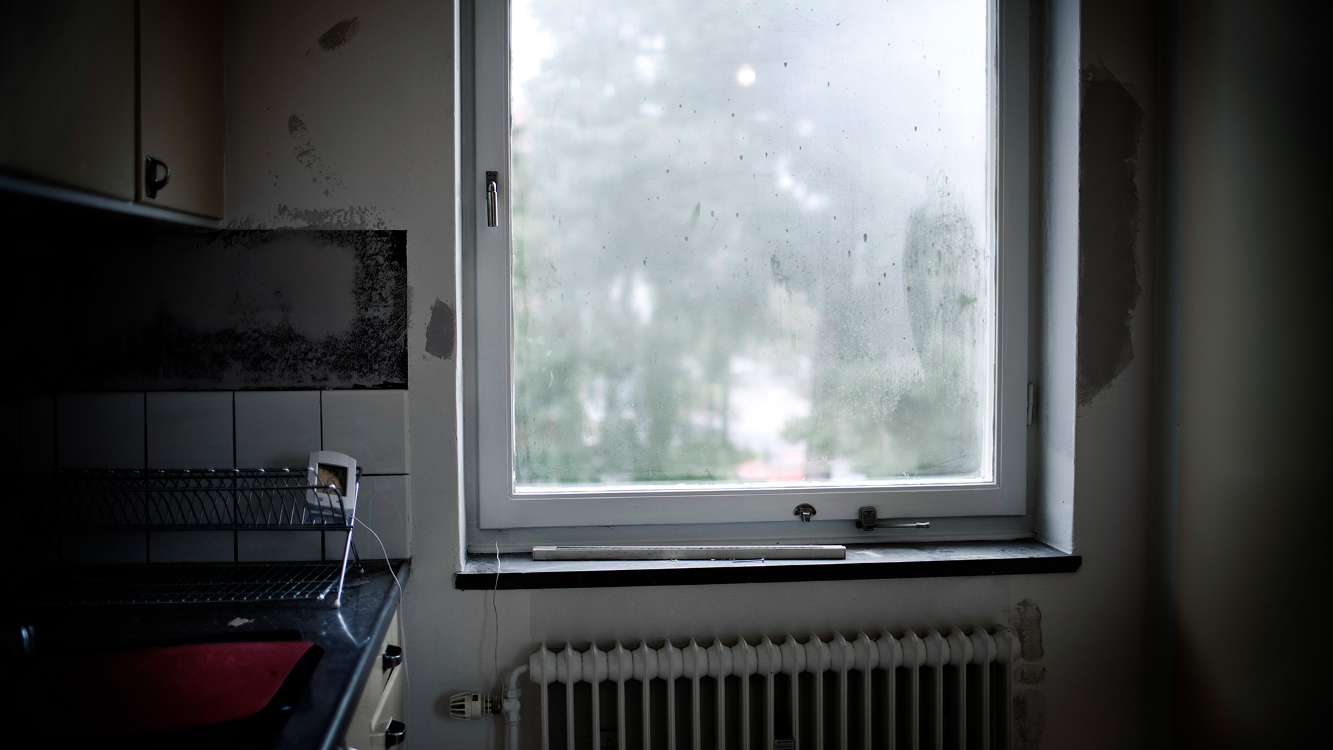 Köksinteriör med fuktig fönsterruta och värmeelement under fönstret