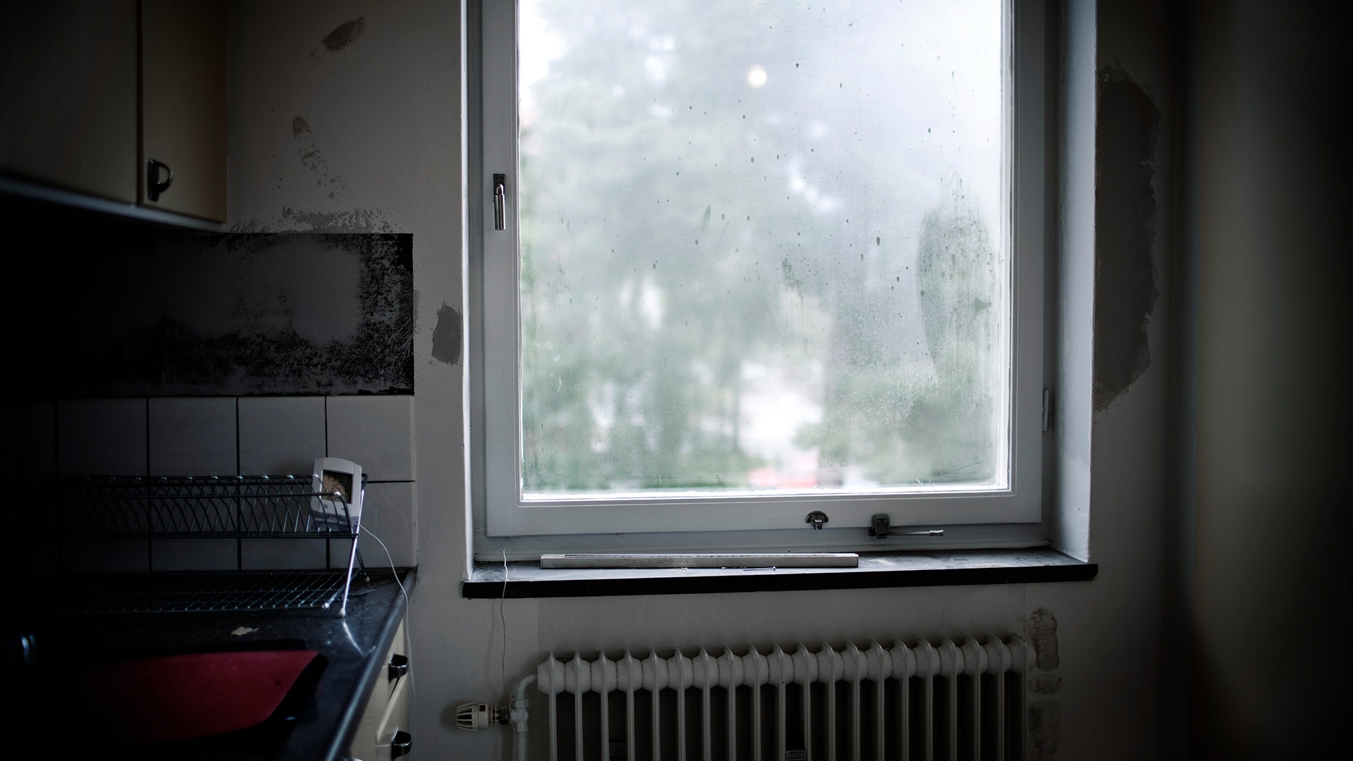 Köksinteriör med fuktig fönsterruta och värmeelement under fönstret