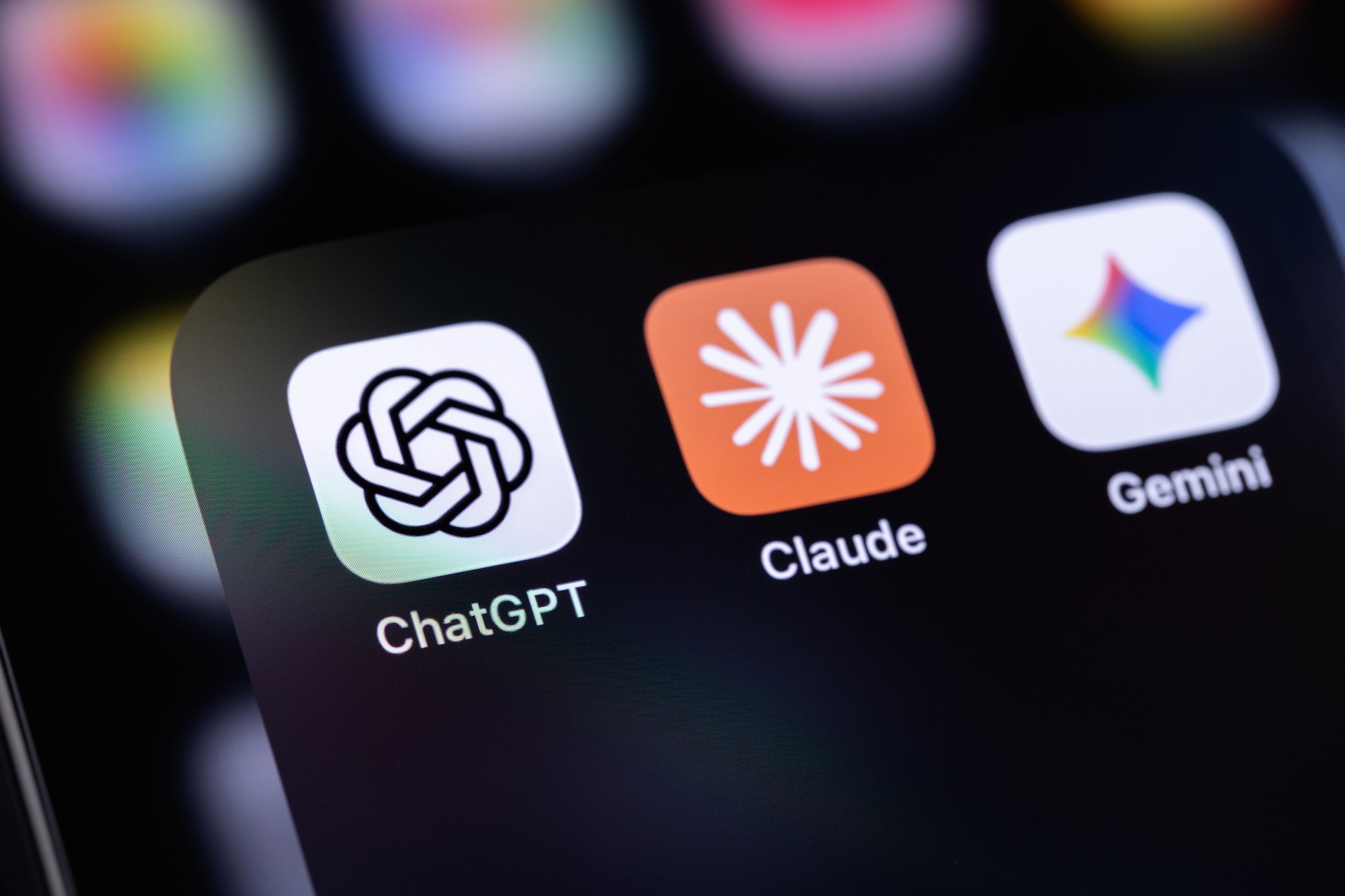 Tre AI-assistantappar visas på en smartphoneskärm: ChatGPT, Claude och Gemini.