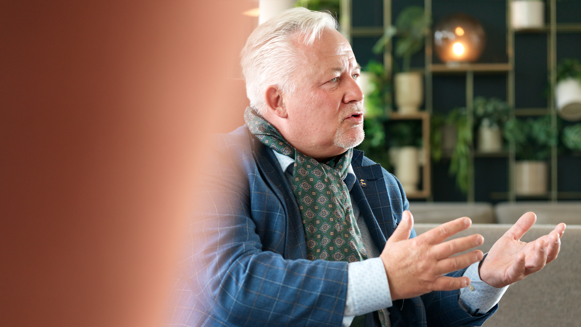 Kent Härstedt intervjuas i Singapore. Han har blå rutig kavaj, ljusblå skjorta och grön mönstrat scarf runt halsen. 