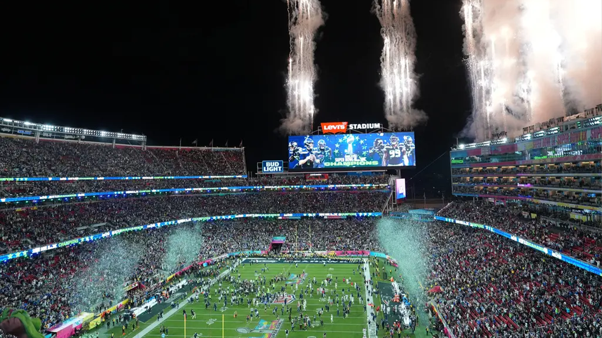 Fullsatt fotbollsstadion med publik och konfetti som skjuts upp från kanoner
