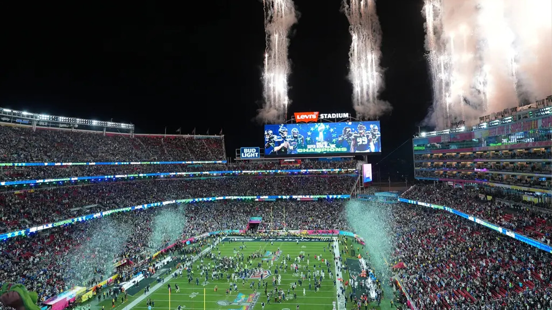 Fullsatt fotbollsstadion med publik och konfetti som skjuts upp från kanoner