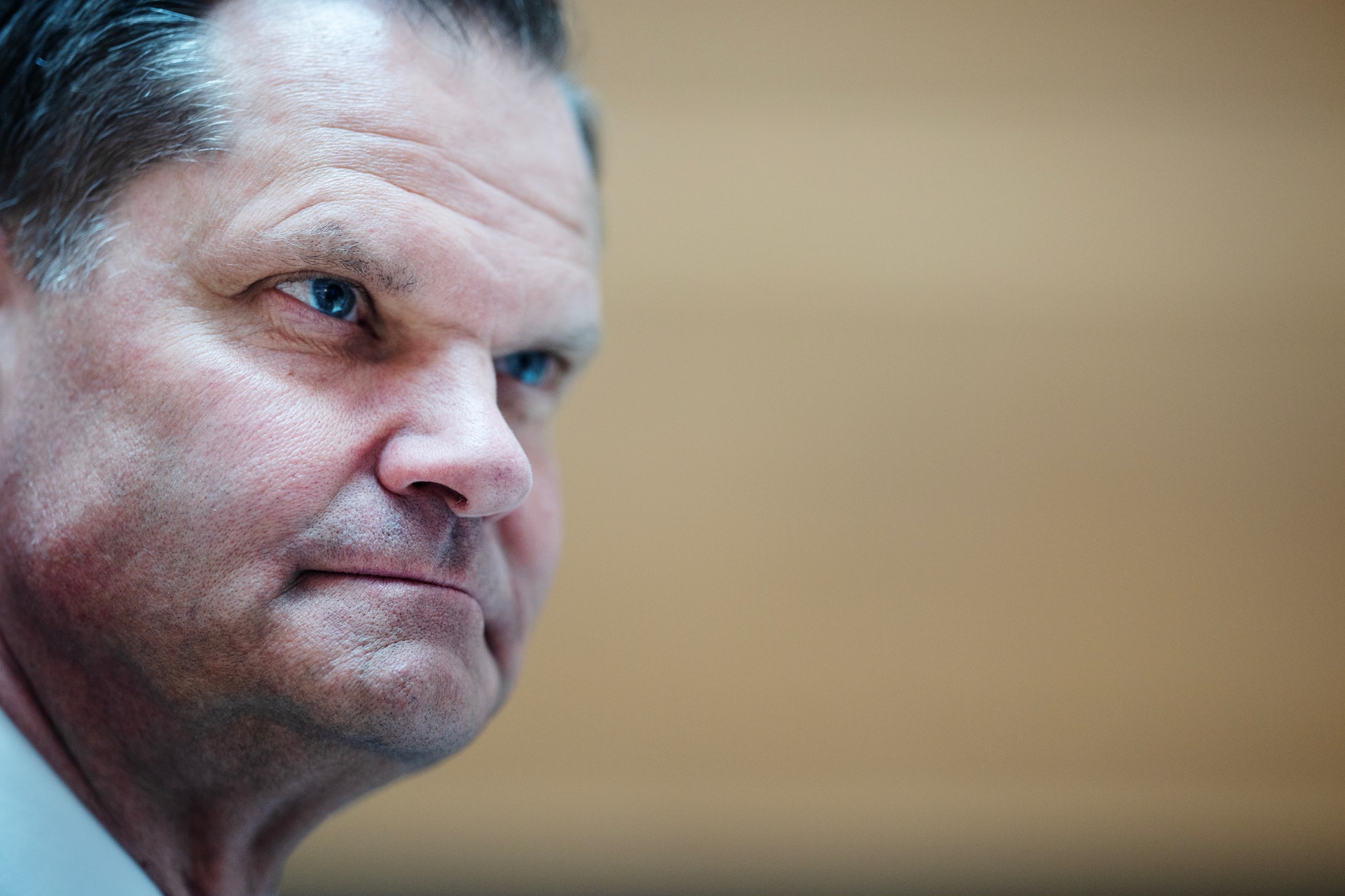 Porträttfoto av en man i profil mot neutral bakgrund.