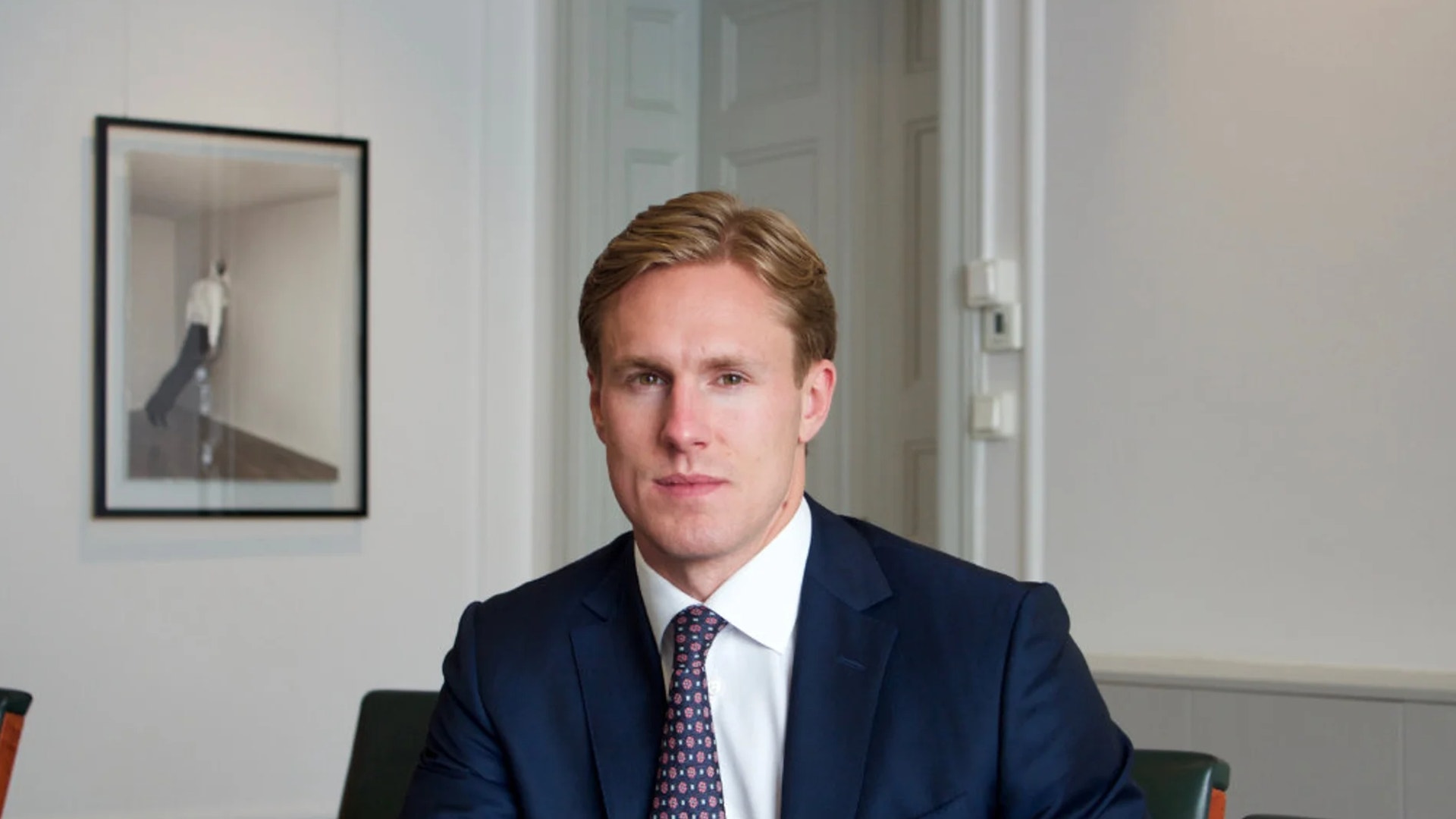 Porträtt av Alexander Jansson, vd för CB Fonder, sittande i mörk kostym och slips i ett kontorsrum.