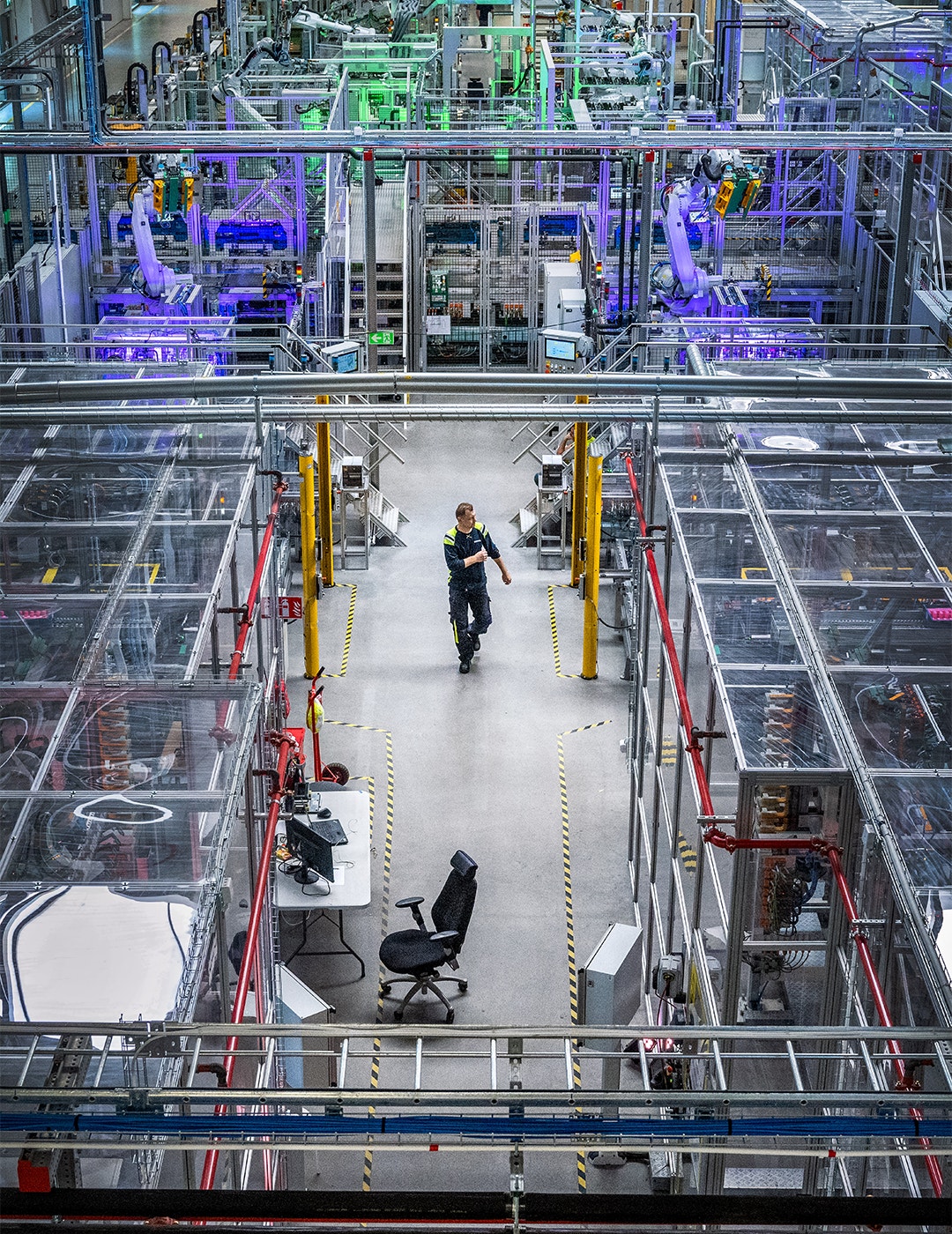 Fabriksgolv på Scania-fabrik med robotar och arbetare vid monteringsstationen