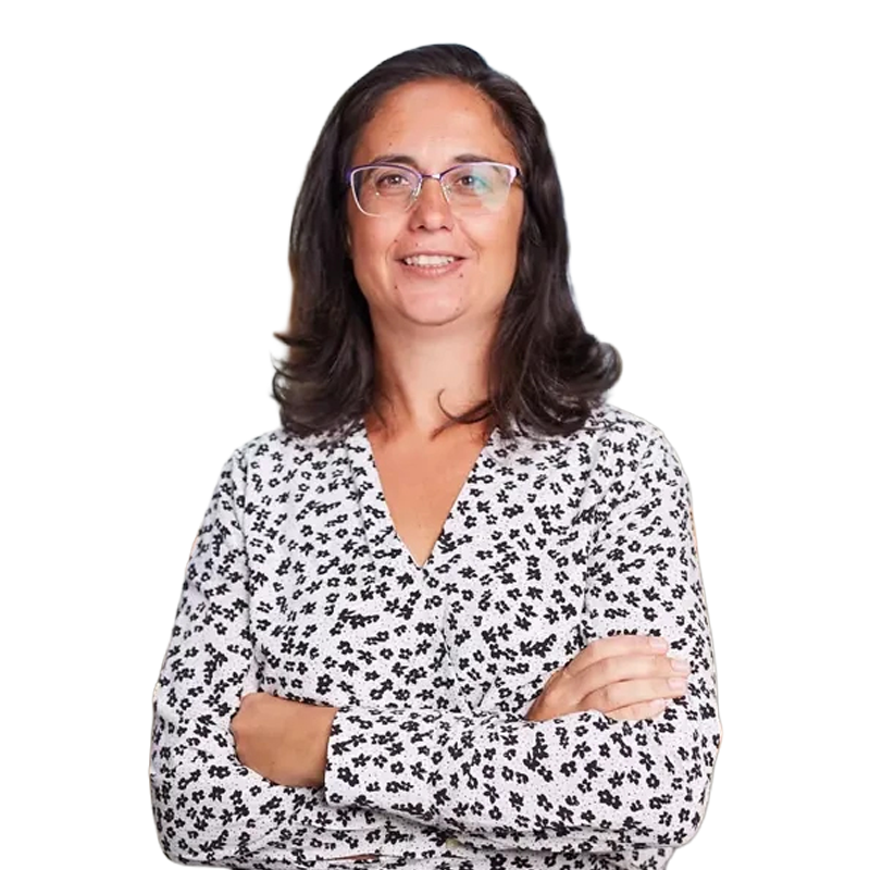 Porträttfoto av en kvinna med långt svart hår och glasögon, klädd i en vit blus med svart mönster.