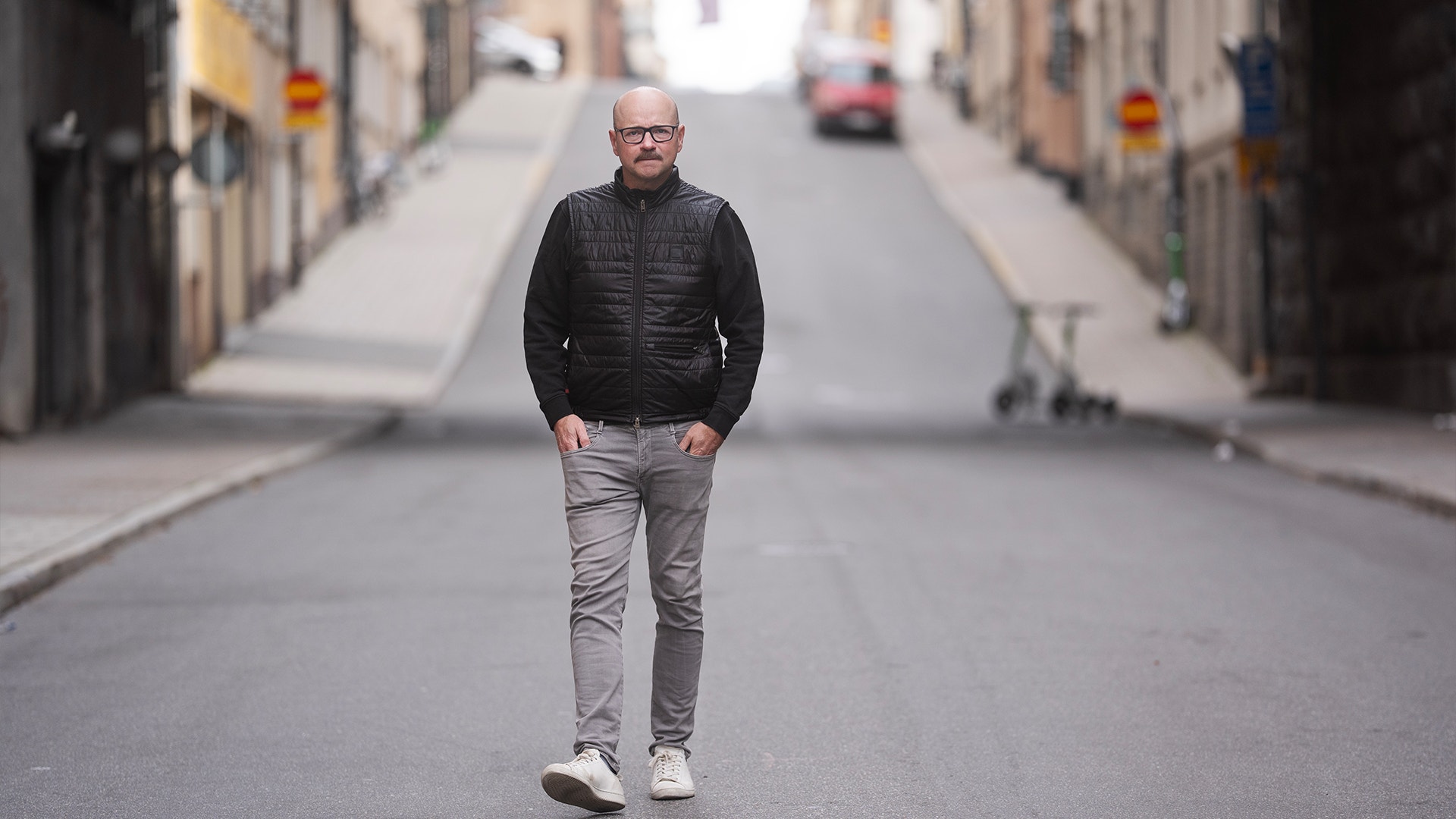 Pål Ahlsén går på gatan, mot fotografen. Han har händerna i fickorna.