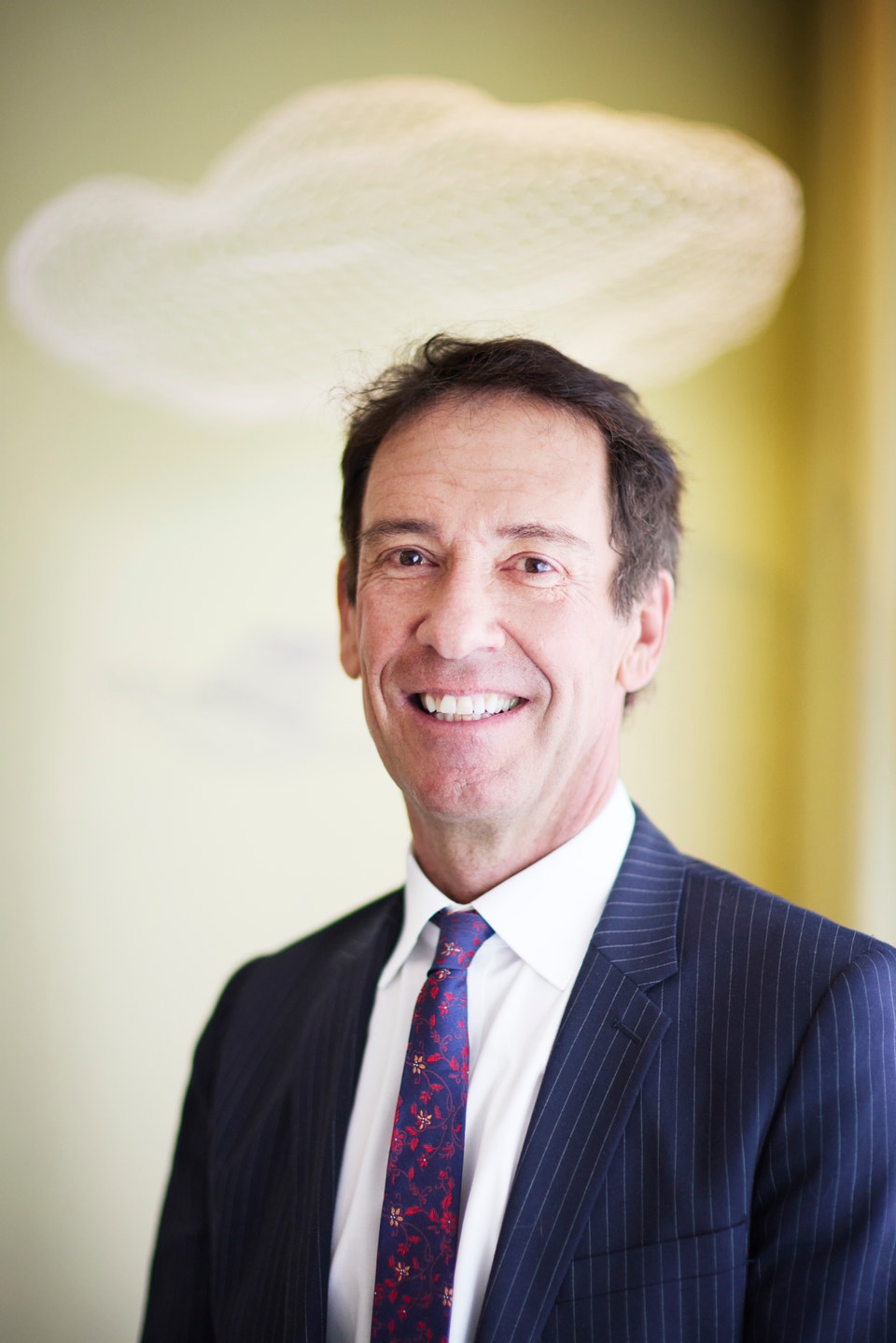 Byron Sharp ler in i kameran, ovanför hans huvud skymtar en skulptur av ett moln.