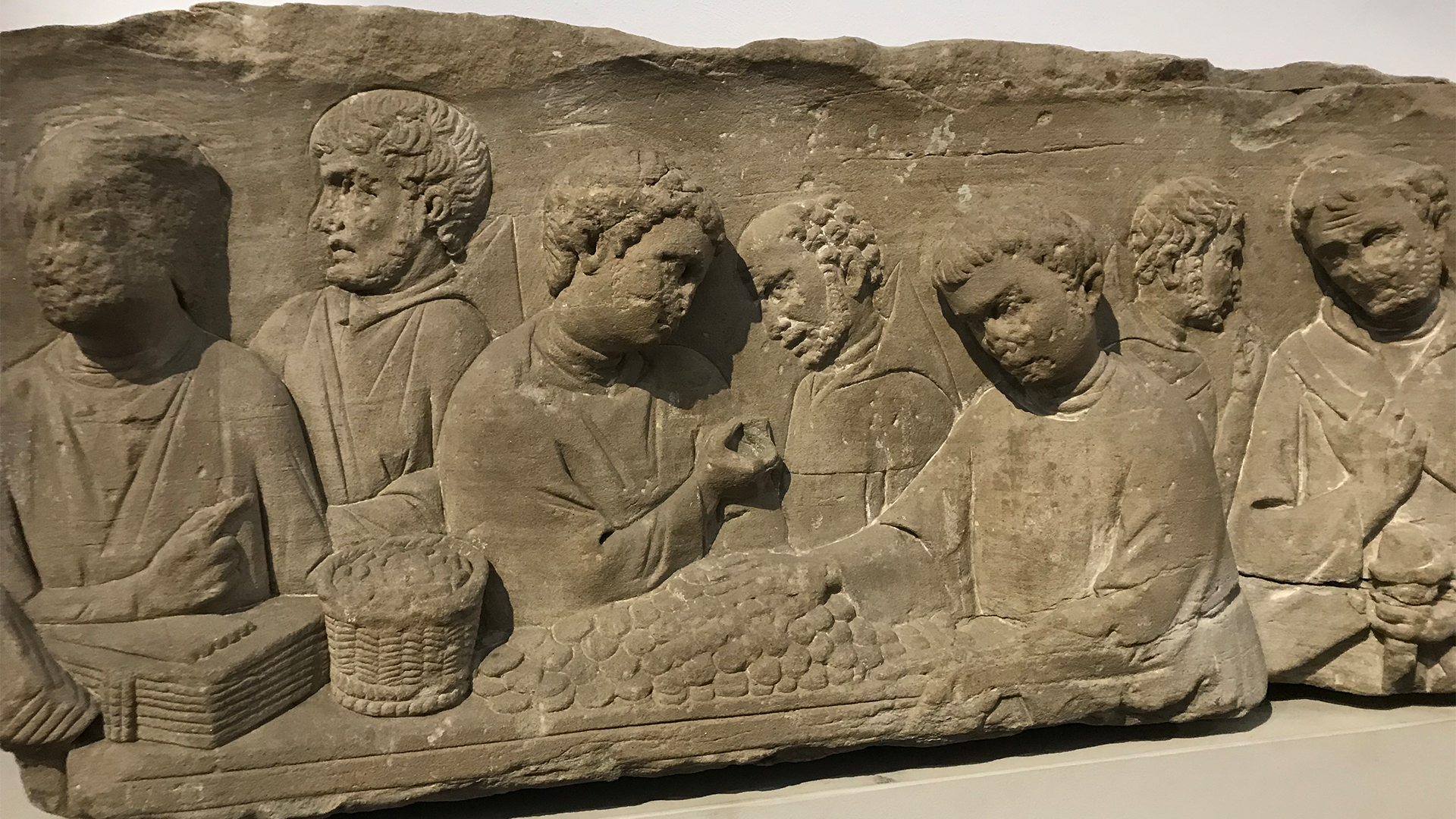 Antik stenrelief med flera människofigurer i relief, möjligen från romersk tid eller tidigare perioder.
