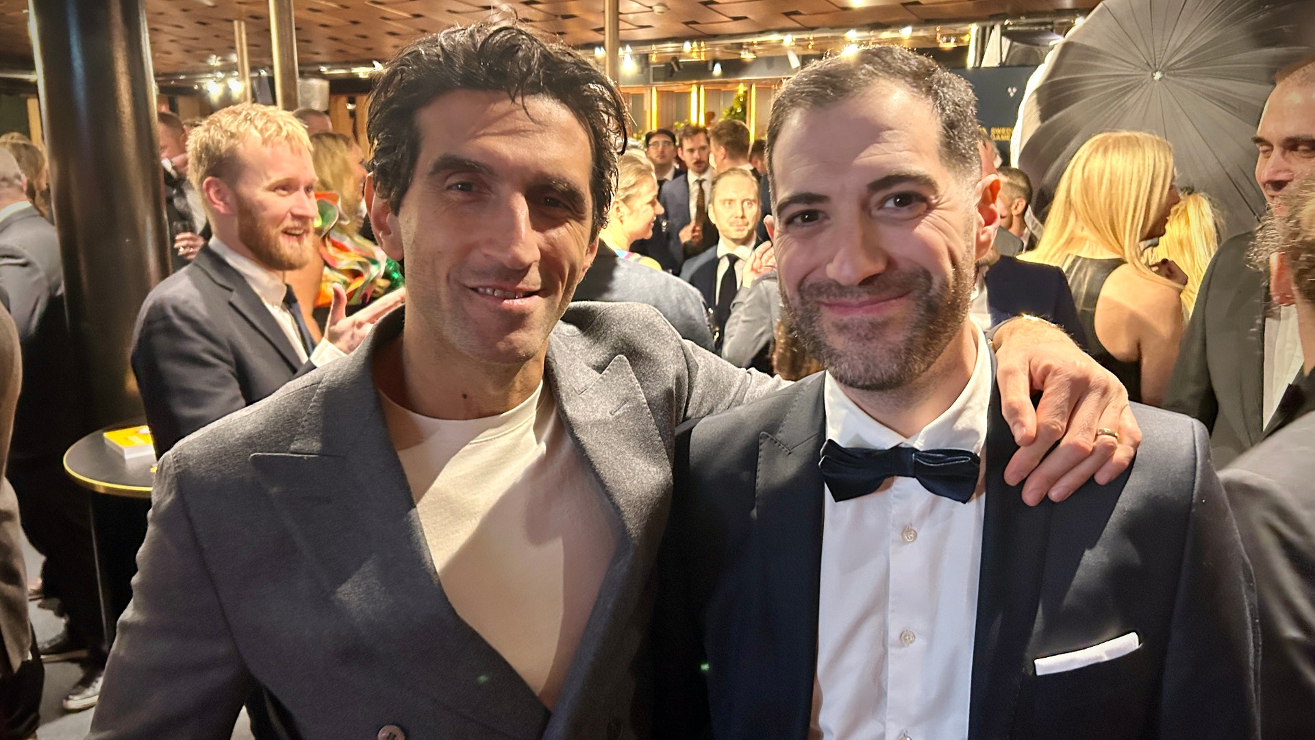 Två män i formell klädsel på en festlig sammankomst.