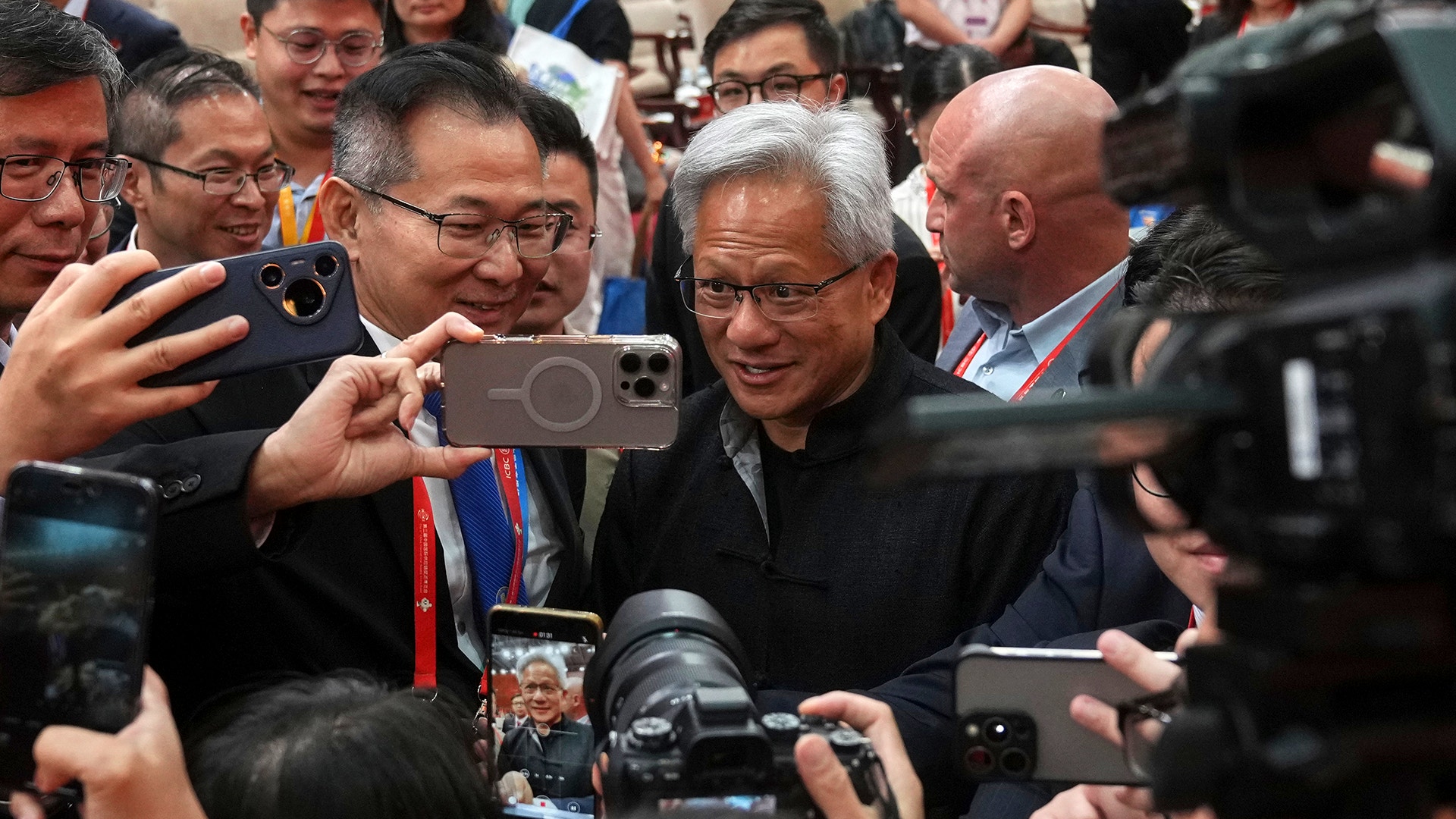Jensen Huang är omringad av personer som vill bli fotad med honom.