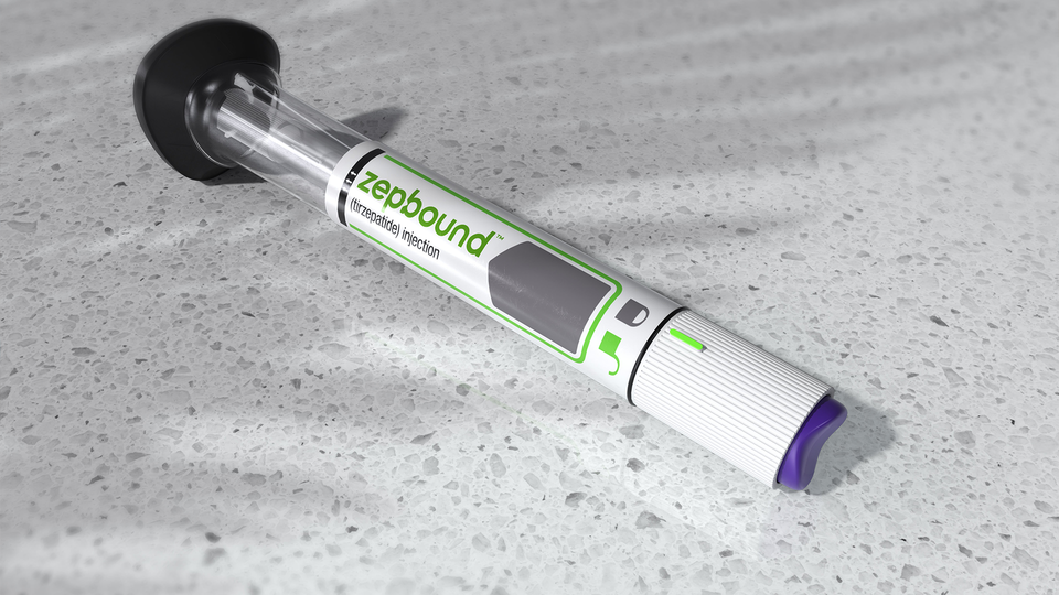 En medicinsk spruta med grön etikett ligger på en betongyta.