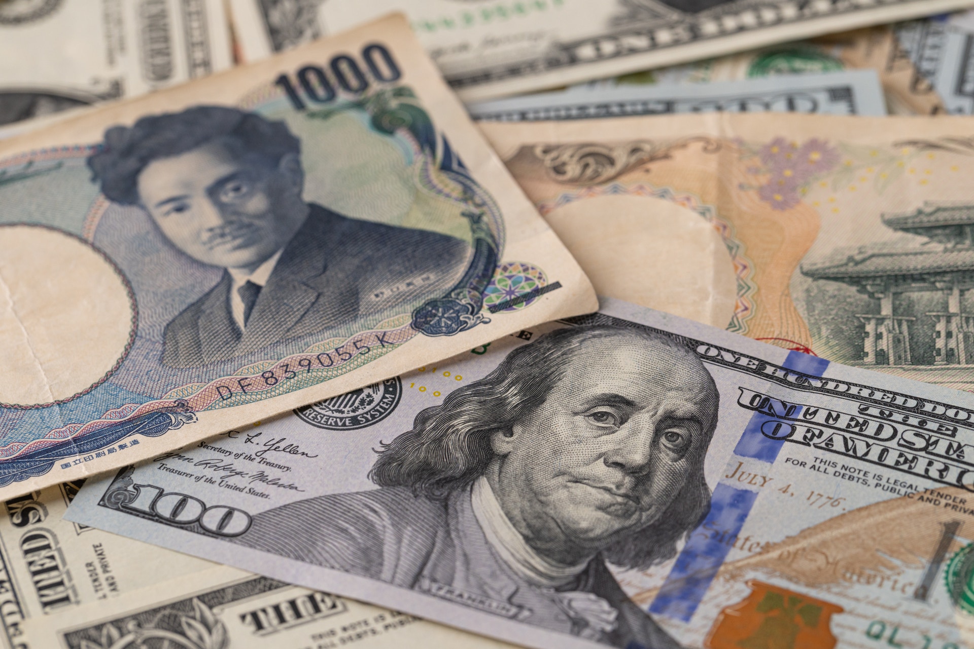 Japanska yenasedlar och amerikanska dollarsedlar överlappade på varandra.