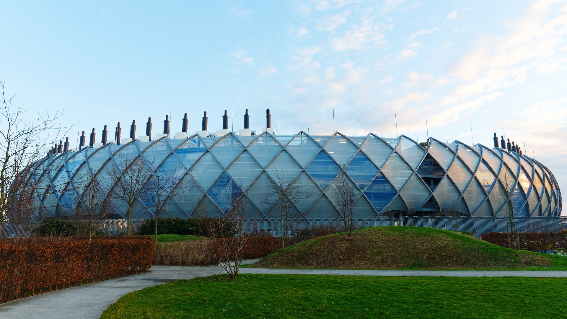 Modernt datacenter med karakteristisk geometrisk glasarkitektur och grön omgivning