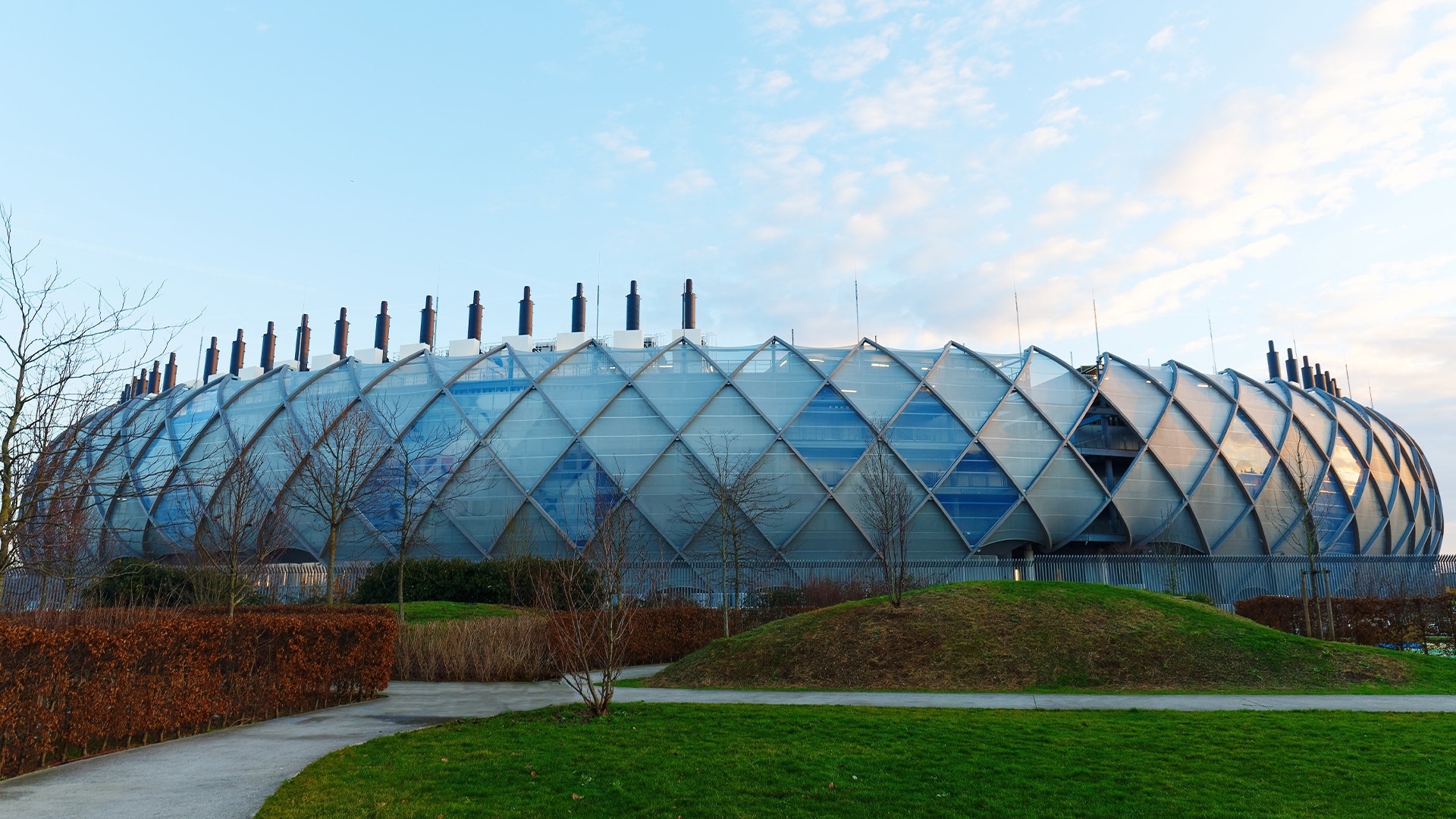 Modernt datacenter med karakteristisk geometrisk glasarkitektur och grön omgivning