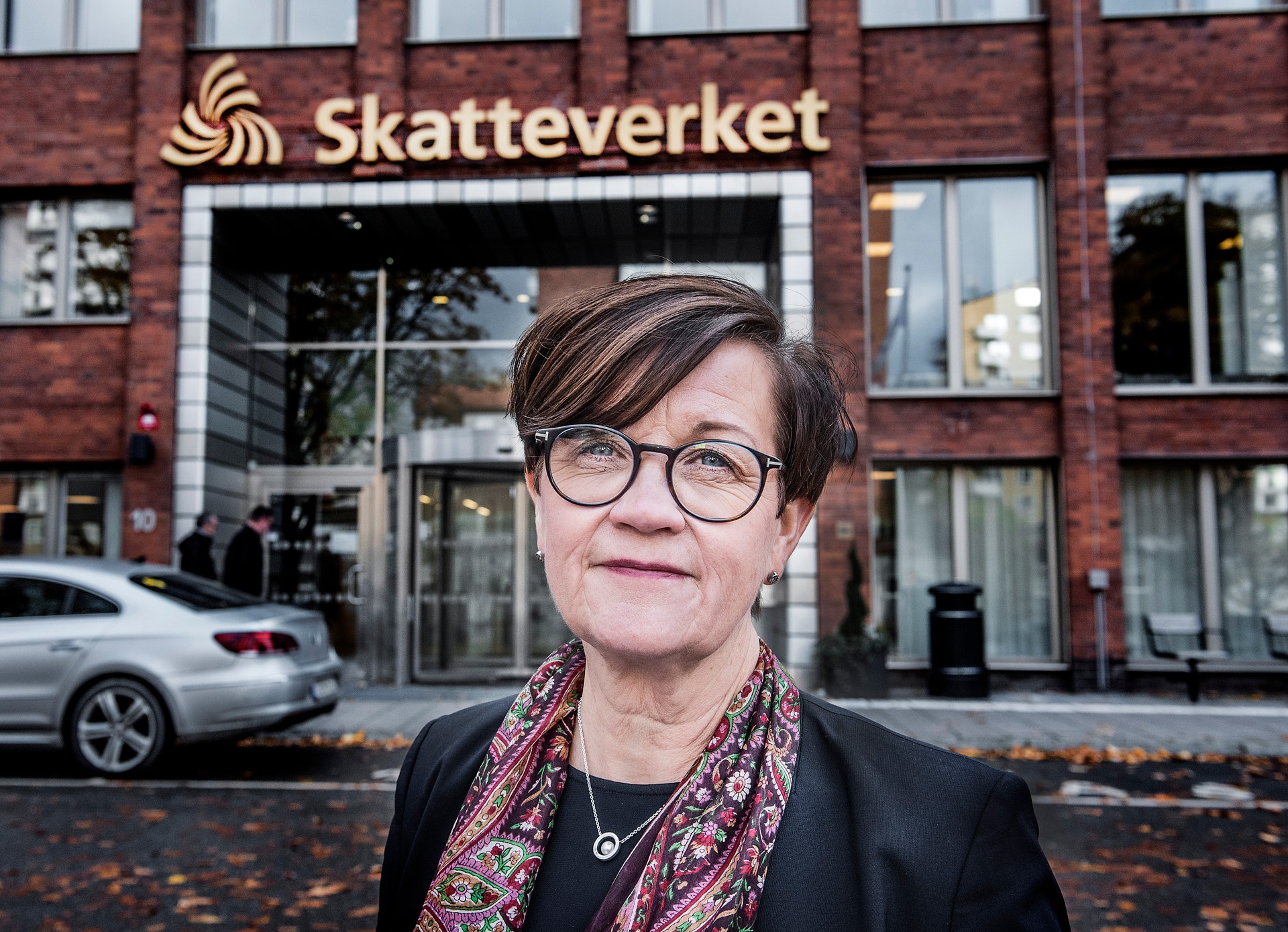 Porträtt av en person med glasögon i ett modernt kontorsrum med en vit disk och en vägg med texten 'PENSIONS MYNDIGHETEN' i bakgrunden.